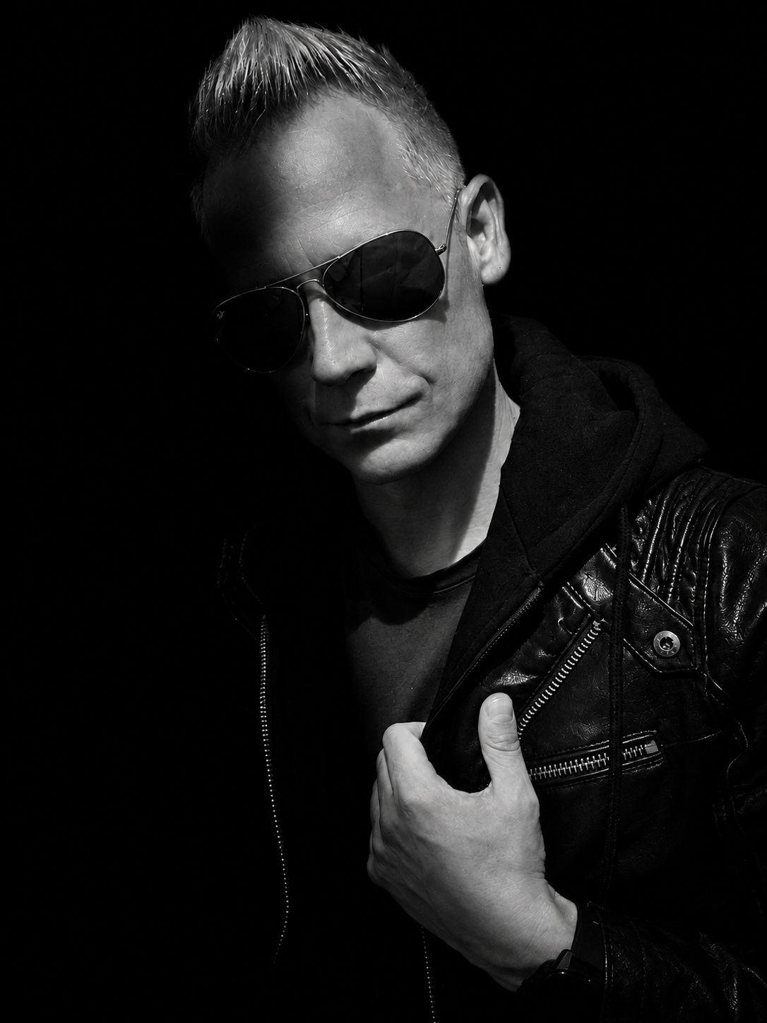 Black-and-white portrait of MINDLOOP wearing sunglasses and a dark jacket